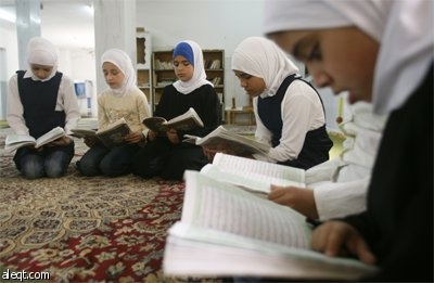 فتاة فلسطينية تقرأ القرآن الكريم في مسجد في مدينة نابلس في اليوم الأول من أيام شهر رمضان المبارك.