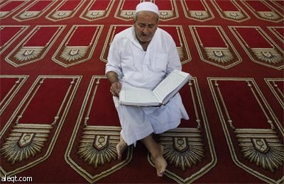 فتاة فلسطينية تقرأ القرآن الكريم في مسجد في مدينة نابلس في اليوم الأول من أيام شهر رمضان المبارك.