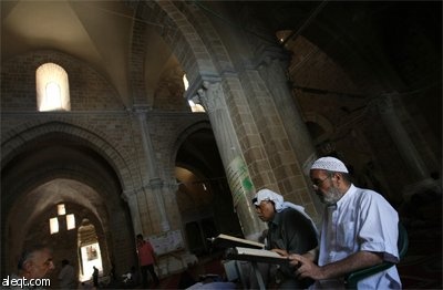 فتاة فلسطينية تقرأ القرآن الكريم في مسجد في مدينة نابلس في اليوم الأول من أيام شهر رمضان المبارك.