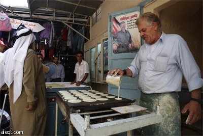 فلسطينيون  يبيعون الحلويات في متجر في مدينة نابلس خلال اليوم الثاني من شهر رمضان.