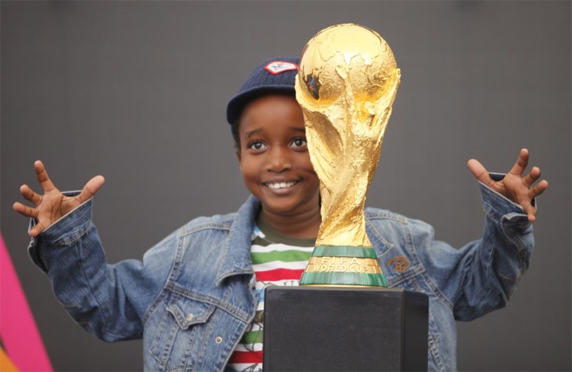 فتى جنوب أفريقي يحضن كأس العالم في العاصمة جوهانسبرغ.