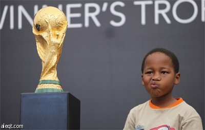 فتى جنوب أفريقي يحضن كأس العالم في العاصمة جوهانسبرغ.