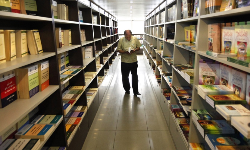 لبناني يتصفح الكتب المعروضة داخل دار الهادي للنشر في الضاحية الجنوبية لبيروت.