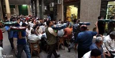 صائمو رمضان يستعدون للإفطار داخل "خيمة الرحمة" في حي شعبي في القاهرة.