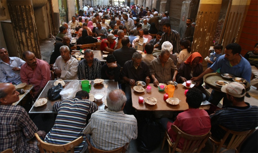 صائمو رمضان يستعدون للإفطار داخل "خيمة الرحمة" في حي شعبي في القاهرة.