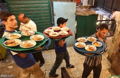 صائمو رمضان يستعدون للإفطار داخل "خيمة الرحمة" في حي شعبي في القاهرة.