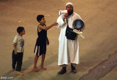 الحاج مسحراتي يجوب شوارع القاهرة لإيقاظ سكانها وتناول وجبة السحور.