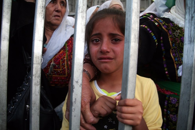 طفلة فلسطينية عند حاجز تفتيش إسرائيلي في بيت لحم حيث تنوي العبور مع عائلتها للقدس لحضور صلاة الجمعة الثانية في رمضان، طال انتظار