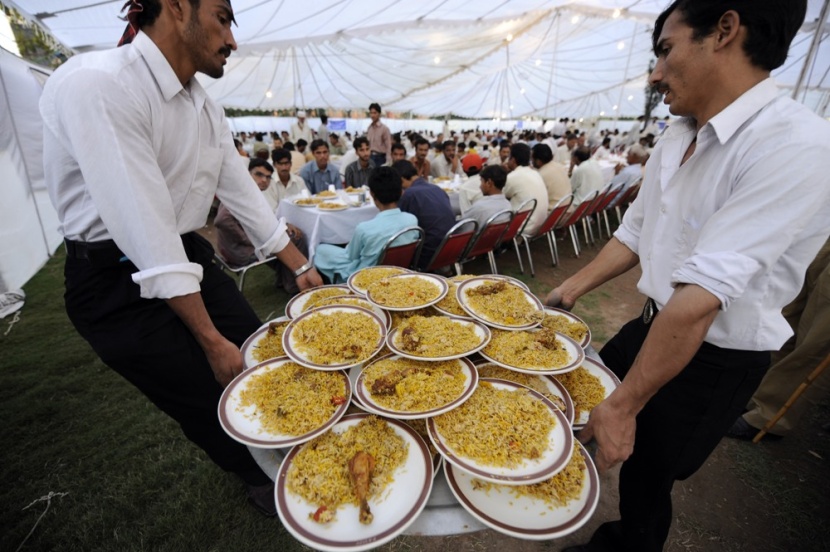باكستانيون يحملون وجبات من الأرز واللحم لتوزيعها على الصائمين في إفطار جماعي..وهو ما يعتبر تقليدا في أغلب البلدان الإسلامية.
