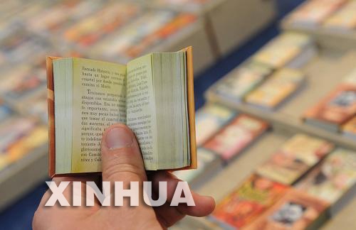 موظف يعرض كتابا صغيرا داخل معرض ألأوراغواي الدولي للكتاب والذي افتتح في العاصمة مونتفيديو ويستمر 10 أيام وبمشاركة ما يزيد عن 80 