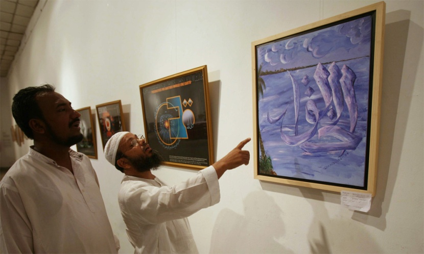 زوار المتحف الوطني في دكا يلقون نظرة على اللوحات العربية المعروضة.