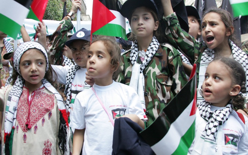 أطفال يرتدون الزي الفلسطيني ويشاركون في  المسيرة التي شارك فيها أكثر من 5000 متظاهر من السوريين والإيرانيين والفلسطينيين في مخيم