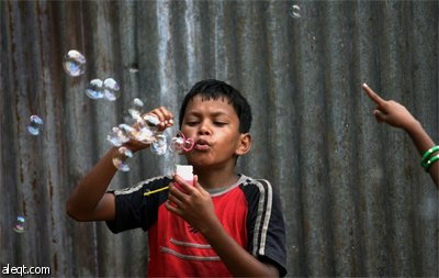 فتاة هندية تلعب وتصنع الفقاعات في محاولة لجذب الزبائن في مومباي.