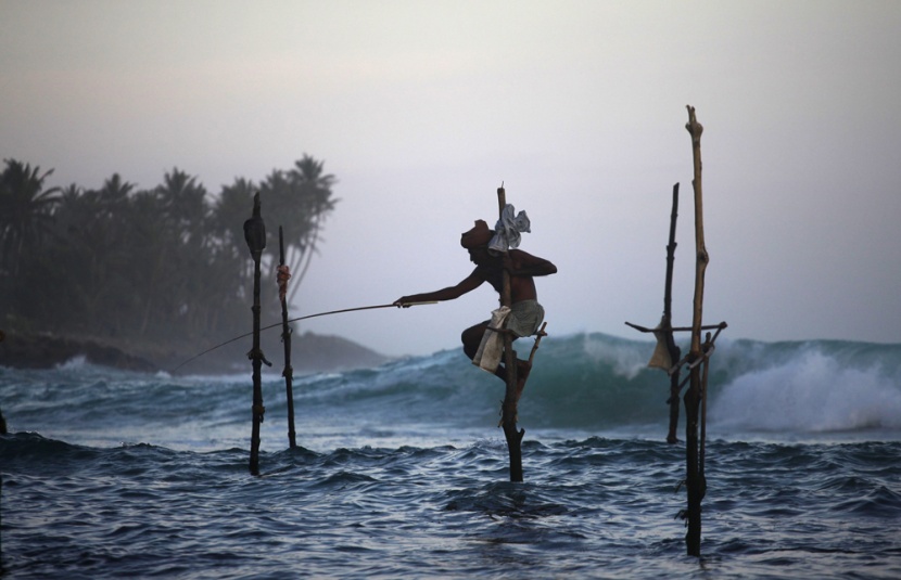 صيادون (STICK FISHER) يصطادون ويجلسون على العصى للصيد في وسط البحر ويعدون أحد المعالم الرئيسة في سيرلانكا.