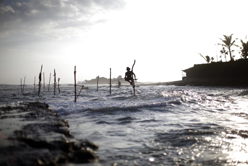 صيادون (STICK FISHER) يصطادون ويجلسون على العصى للصيد في وسط البحر ويعدون أحد المعالم الرئيسة في سيرلانكا.
