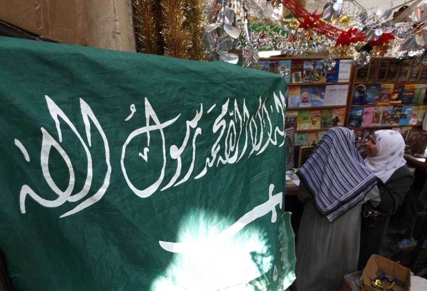 سوريتان تتبضعان من متجر متخصص في بيع الكتب وأدوات الزينة إلى جانب الأعلام السعودية في سوق الحميدية الشعبي في دمشق.