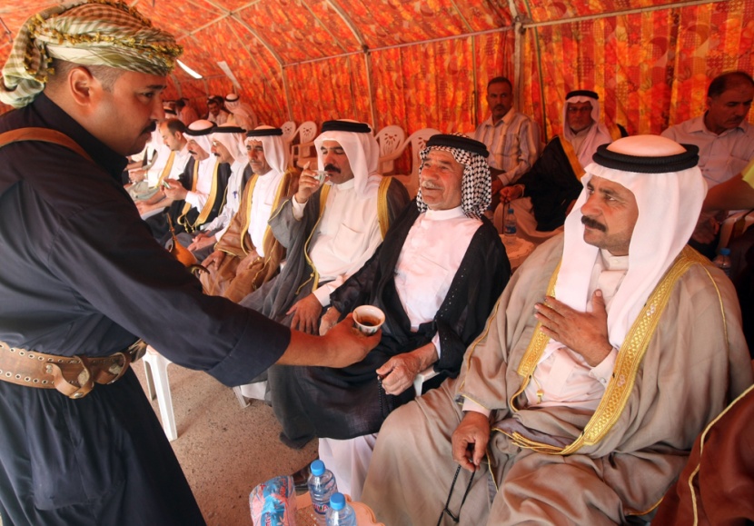 عراقي يكرم ضيوفه ويصب القهوة العربية التقليدية خلال اجتماع لزعماء القبائل السنية في بغداد لتعلن مشاركتها في انتخابات يناير القاد