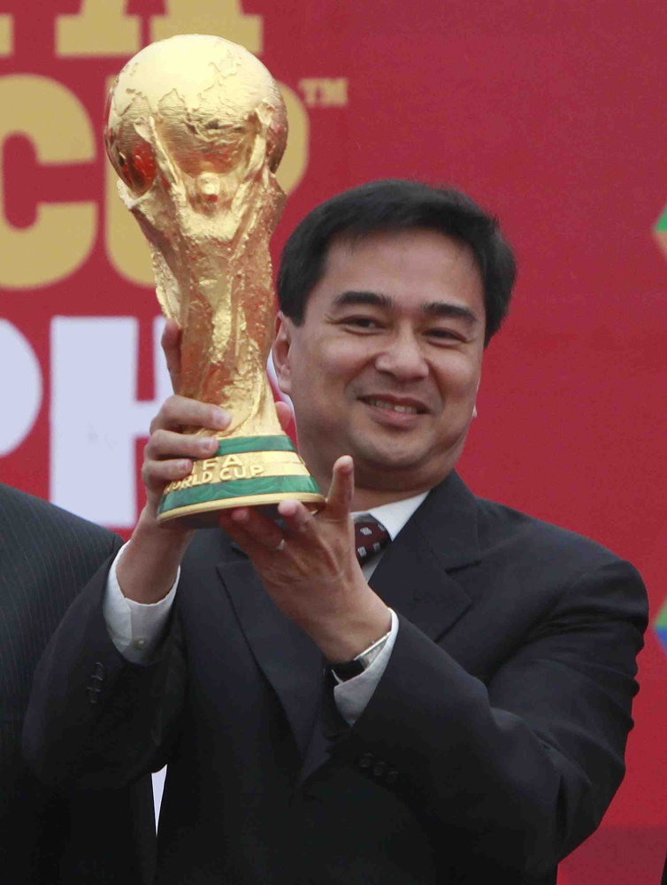 رئيس الوزراء التايلاندي يحمل كأس العالم لكرة القدم خلال حفل ترويجي لبطولة كأس العالم لكرة القدم في بانكوك.