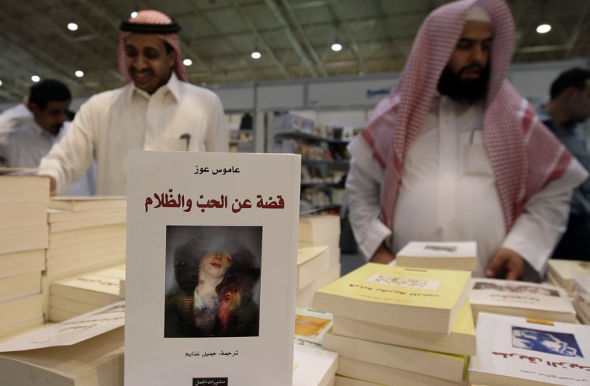 سعوديون يلقون نظرة على النسخة العربية من كتاب الإسرائيلي عاموس عوز "قصة عن الحب والظلام" والمعروض في معرض الرياض الدولي الخامس ل