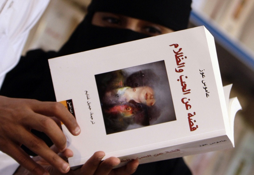 سعوديون يلقون نظرة على النسخة العربية من كتاب الإسرائيلي عاموس عوز "قصة عن الحب والظلام" والمعروض في معرض الرياض الدولي الخامس ل