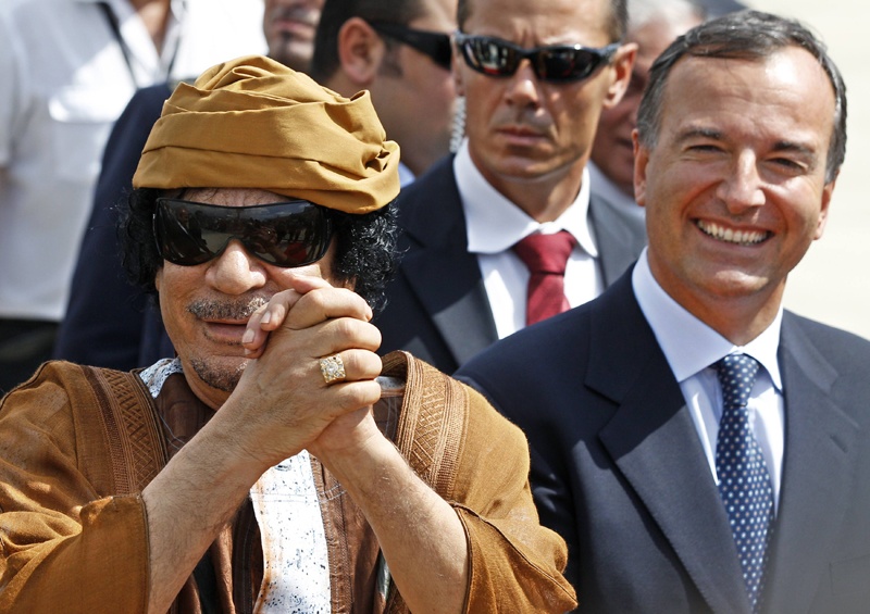 أحد أفراد الوفد المرافق للرئيس الليبي معمر القذافي يحمل ملابسه من الطائرة التي أقلتهم إلى روما للاحتفال السنوي الثاني بيوم الصدا