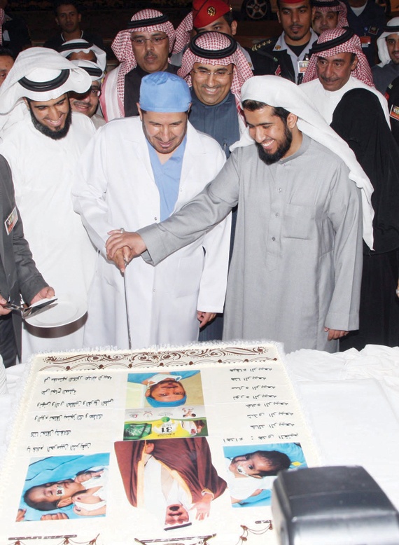 وزير الصحة ووالد التوأم السيامي السعودي عبد الله وسلمان يقطعان تورتة الاحتفال بنجاح عملية فصلهما
