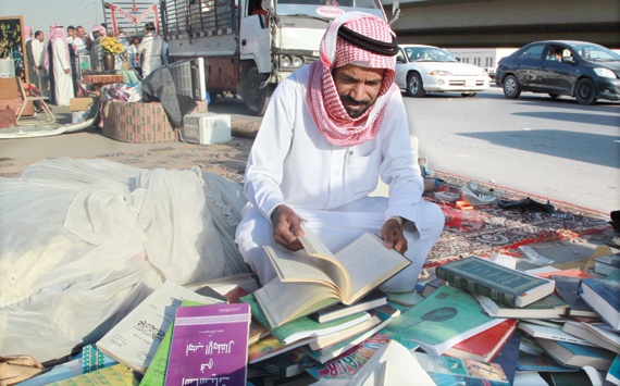 بائع كتب يستغل مساحة من الشارع لعرض كتب قديمة في أحد شوارع الرياض