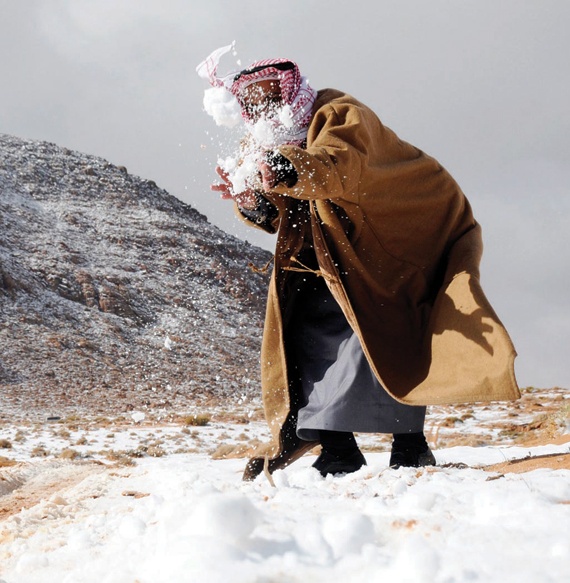 سعودي يلهو بأكوام الثلوج، إثر عاصفة ثلجية كست جبال تبوك