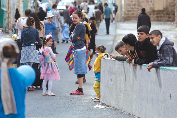 ناس وناس:أطفال فلسطينيون يقفون خلف حاجز أسمنتي لمشاهدة أطفال إسرائيليين خلال احتفال في منطقة بالضفة الغربية