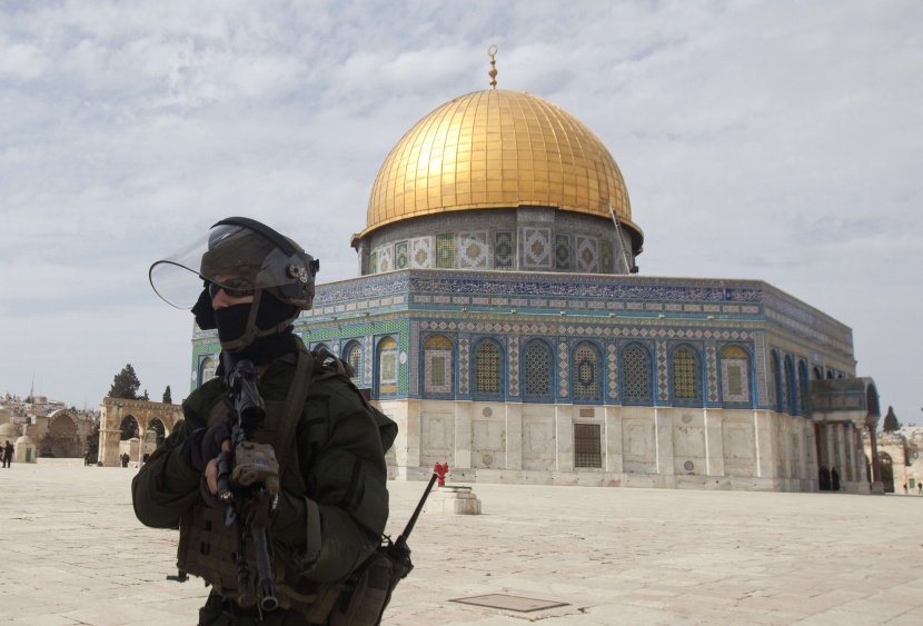 شرطي إسرائيلي يقف مع بدء  اشتباكات مع متظاهرين فلسطينيين بعد صلاة الجمعة