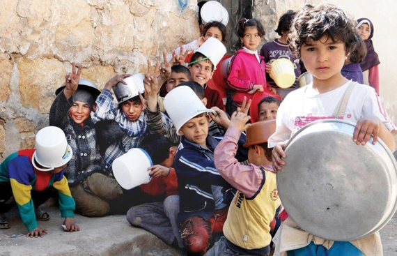ناس وناس: صورة وزعها المركز الإعلامي في حلب، تظهر أطفالا سوريين يحملون أوعية بانتظار توزيع الطعام أمس في حلب