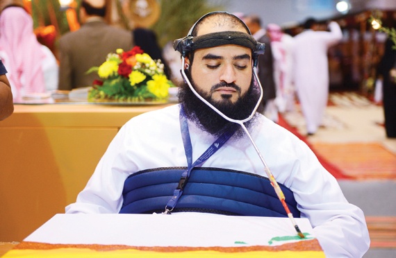 ناس وناس: أحد ذوي الاحتياجات الخاصة يزاول الرسم برأسه أمس في ملتقى السفر والاستثمار السياحي السعودي بالرياض
