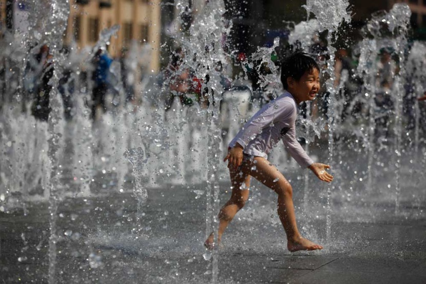 طفل يلعب بين نوافير الماء في العاصمة الكورية سيول