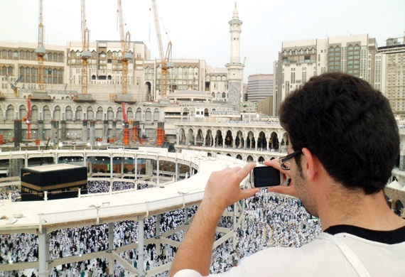 معتمر يلتقط صورا للطائفين حول الكعبة من الطابق العلوي