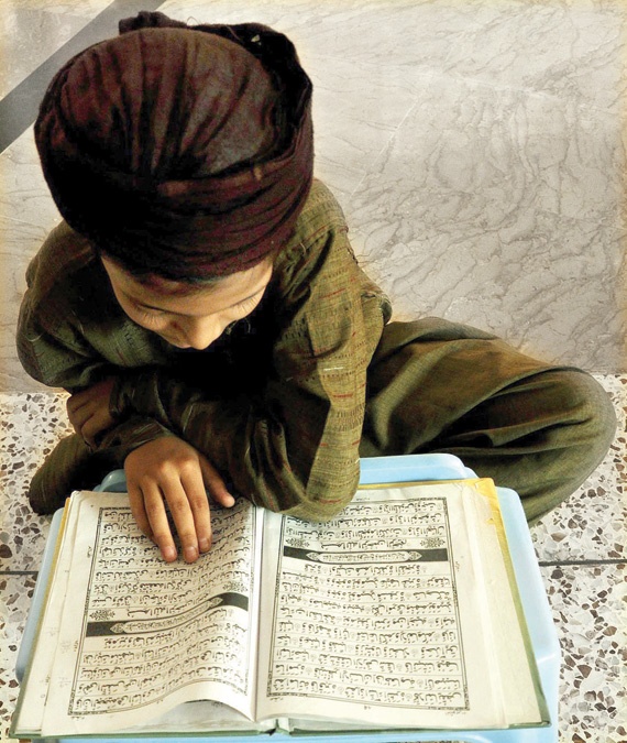 صبي باكستاني يقرأ القرآن الكريم في مسجد في كراتشي أمس.