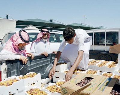 بائع تمر يعرض بعض أصناف التمور على الزبائن في حائل