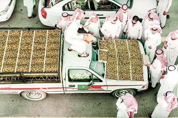 بائع يعرض بضاعته من التمور معتليا سيارته