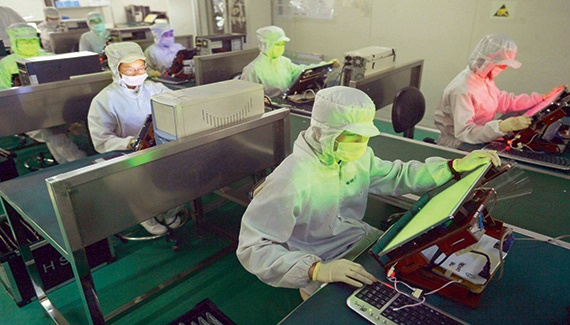 موظفون يعملون داخل أحد أكبر مصانع إنتاج شاشات LCD في الصين