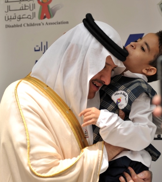 طفل يقبل رأس الأمير سلطان بن سلمان أثناء رعايته اتفاقيات بين حملة " الله يعطيك خيرها " وشركتين وطنيتين .