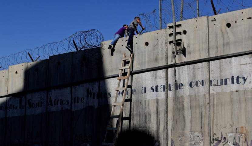 قصة مصورة: فلسطينيون يستخدمون السلالم لتسلق الجدار الفاصل في طريقهم إلى المسجد الأقصى