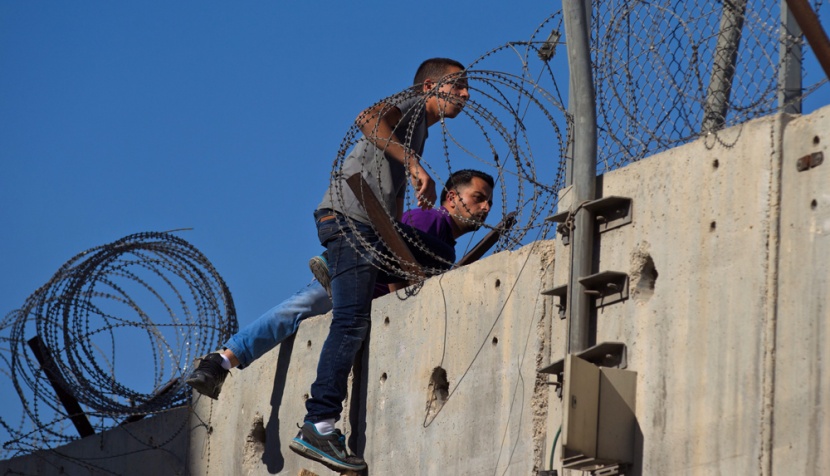 قصة مصورة: فلسطينيون يستخدمون السلالم لتسلق الجدار الفاصل في طريقهم إلى المسجد الأقصى