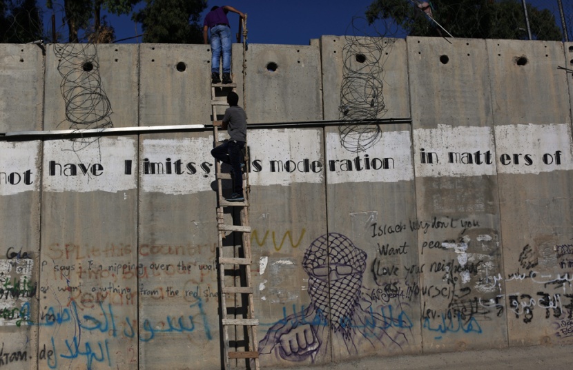 قصة مصورة: فلسطينيون يستخدمون السلالم لتسلق الجدار الفاصل في طريقهم إلى المسجد الأقصى