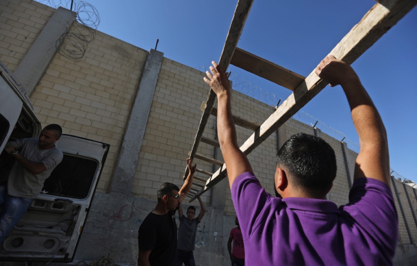 قصة مصورة: فلسطينيون يستخدمون السلالم لتسلق الجدار الفاصل في طريقهم إلى المسجد الأقصى