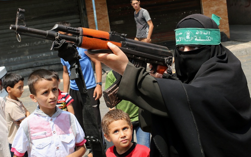 قصة مصورة: امرأة فلسطينية تحمل سلاحاً احتجاجاً على مقتل الفتى أبوخضير