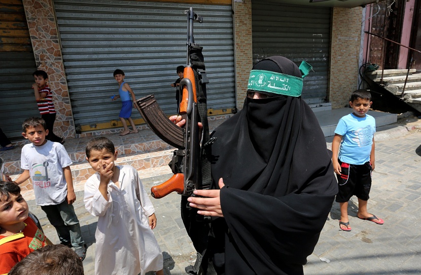 قصة مصورة: امرأة فلسطينية تحمل سلاحاً احتجاجاً على مقتل الفتى أبوخضير