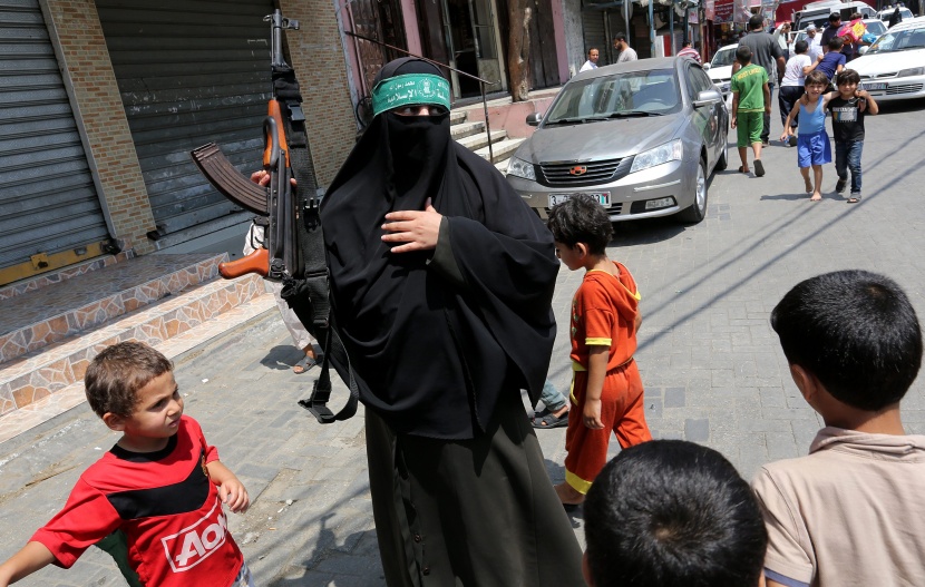 قصة مصورة: امرأة فلسطينية تحمل سلاحاً احتجاجاً على مقتل الفتى أبوخضير