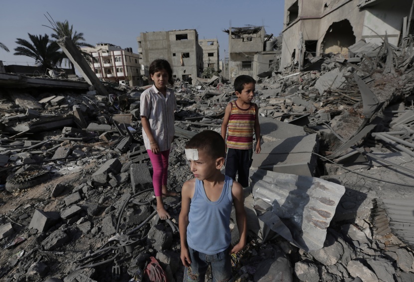 أطفال فلسطينيون يلعبون على الأرجوحة خارج منزلهم الذي تحطم من جراء قصف إسرائيلي