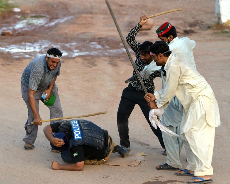 أنصار  حزب المعارض عمران خان يضربون شرطيا خلال اعتصام المعارضة في اسلام اباد