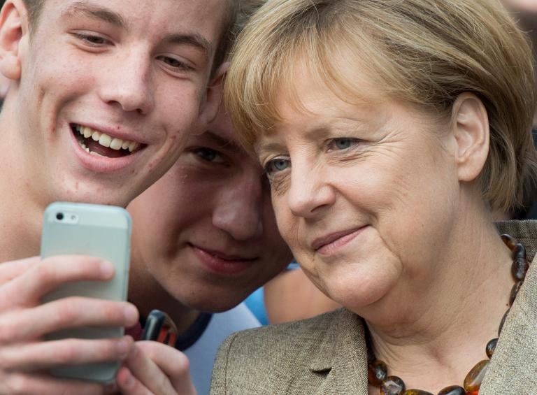 تلميذ مدرسة في المانيا يلتقط صورة سلفي خلال زيارة للمستشارة الالمانية أنغيلا ميركل.