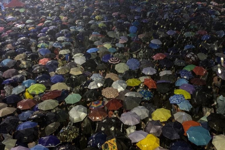 متظاهرون يحملون المظلات تحت المطر خلال تظاهرة للمطالبة بالديموقراطية في هونغ كونغ